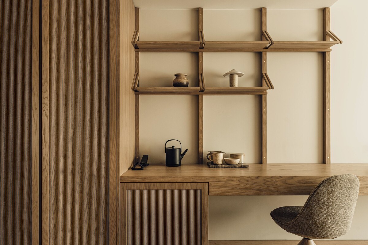 Un bureau en bois avec des étagères, une chaise et une bouilloire.