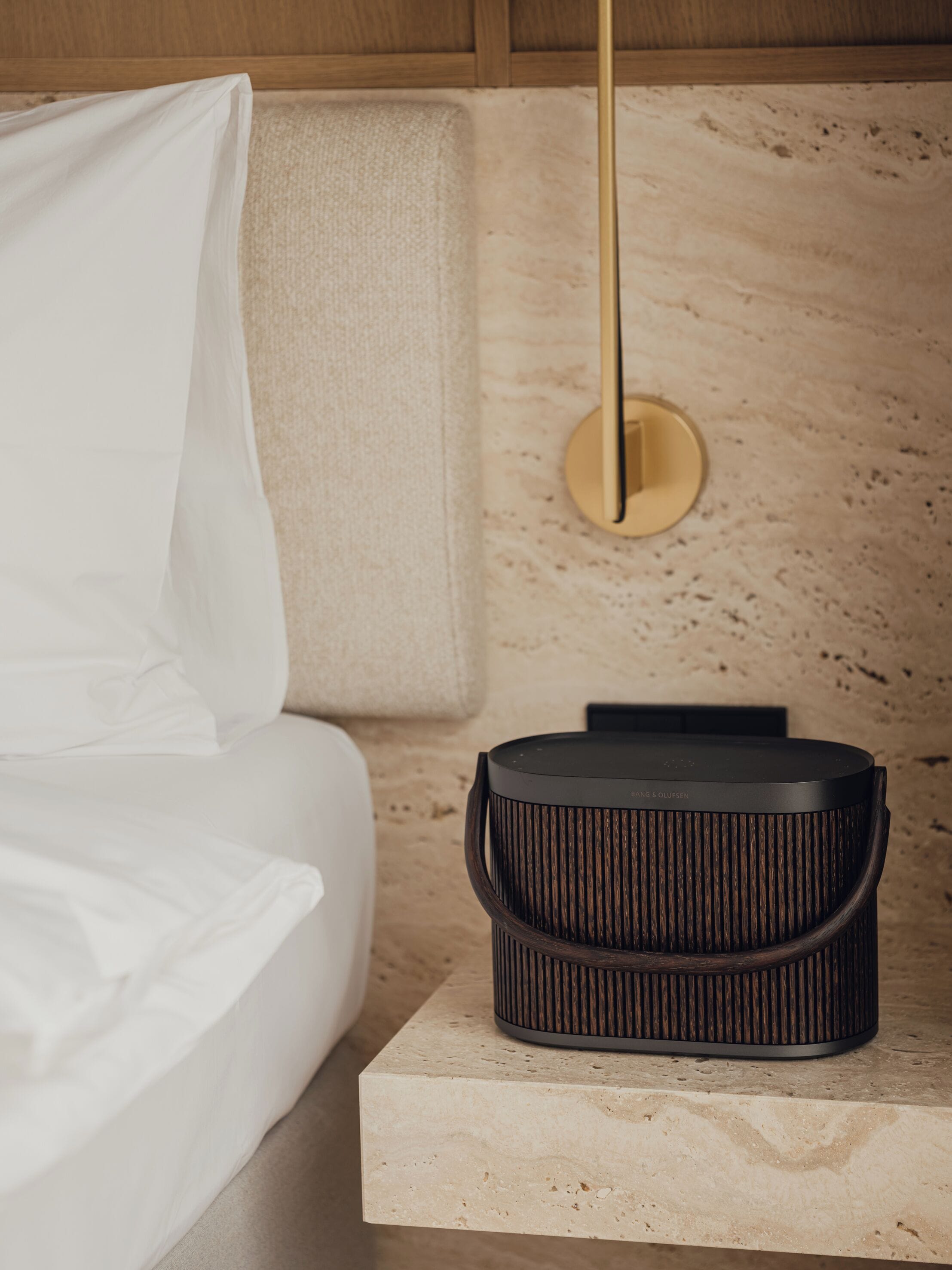Une chambre à coucher moderne avec un lit, une table de chevet et une lampe.