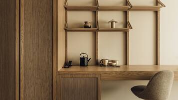 A wooden desk with shelves, a chair, and various kitchen items.