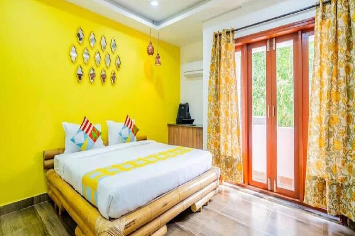 A room with a bed, a ceiling fan, and a window with curtains.