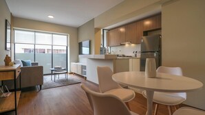 A modern kitchen with a dining area, large windows, and a flat-screen TV. - w* | Glorious 2BR w/ Perfect Balcony Near Kennedy Park (Miraflores)