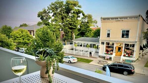 Ein Balkon mit einem Blumentopf, einem Weinglas und einem Buch mit dem Titel 'Bay Life'.