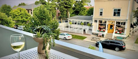 A balcony with a potted plant, a wine glass, and a book titled "Bay Life".