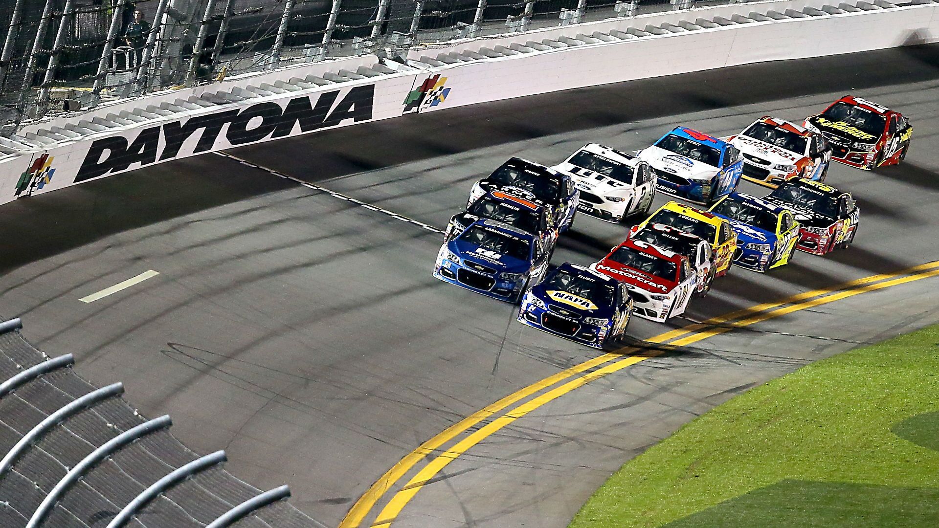 Une course NASCAR sur un circuit où l’on peut clairement voir une enseigne portant le nom « DAYTONA ».