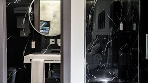A bathroom with a white sink, a mirror, and a towel hanging on the wall. - Karma6Rooms (Catania)