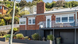 A two-story house with a garage, a balcony, and a brick facade. - Burnie Retreat - Coastal Comfort Awaits (Burnie)