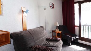 A living room with a sofa, a lamp, a chair, and a small table.