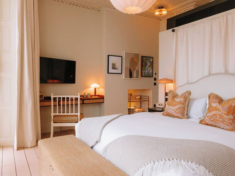 Ein Hotelzimmer mit einem großen Bett, einem Schreibtisch und einem Fernseher.