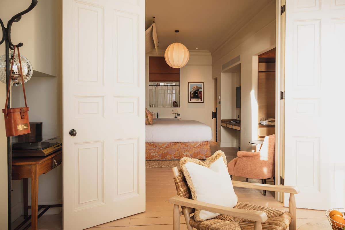 Una habitación de hotel con una cama, una silla, un escritorio y un armario.