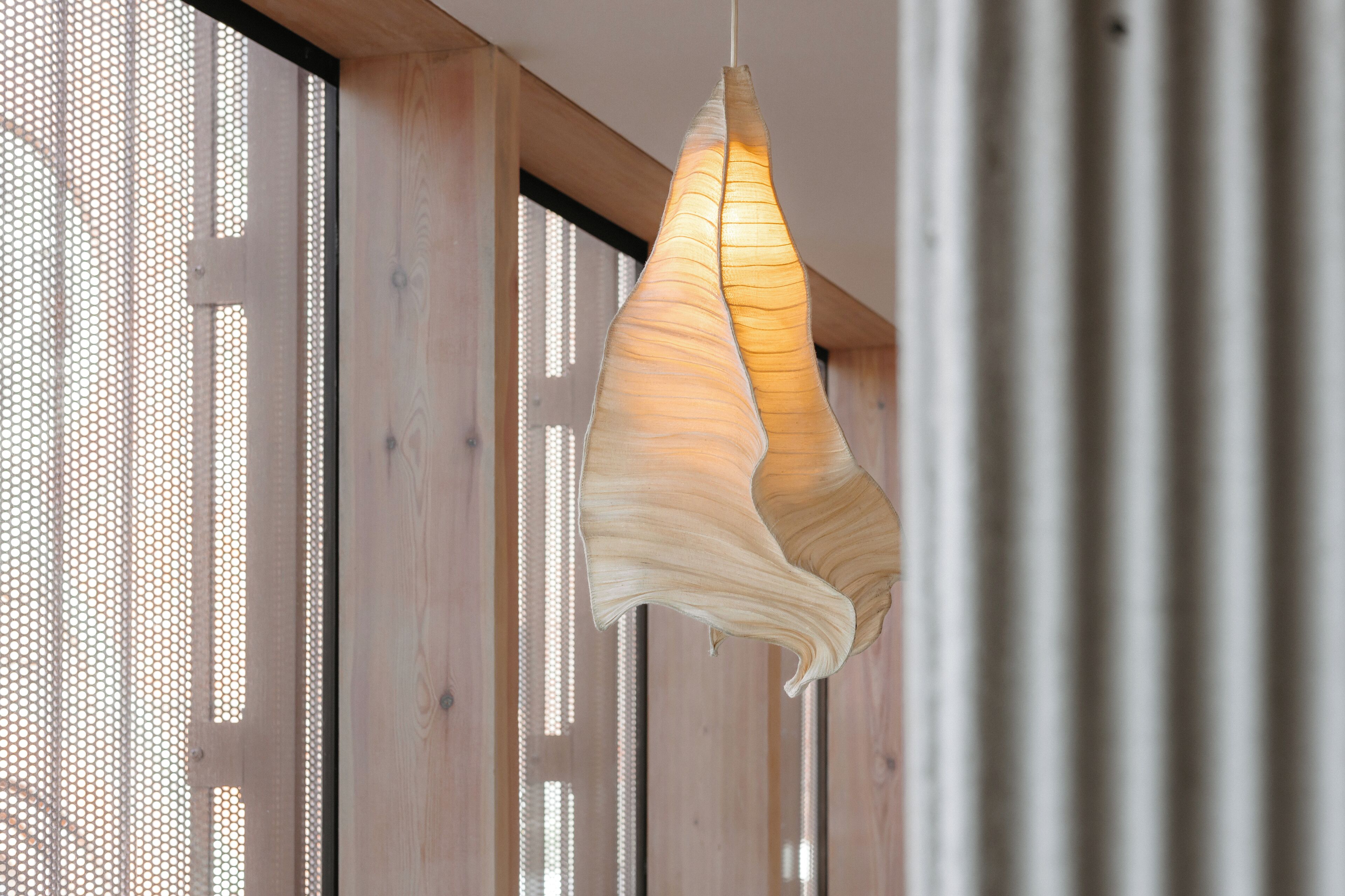 A modern interior with wooden paneling and a hanging light fixture.