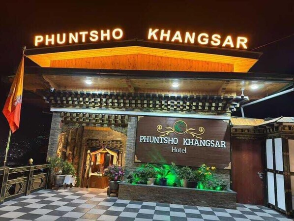The entrance of Phuntsho Khangsar Hotel with a checkered floor and a flag. - Phuntsho Khangsar Hotel (Thimphu)