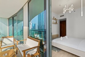 Une chambre d’hôtel moderne dotée d’un balcon, d’un lit, d’un bureau et d’une chaise.