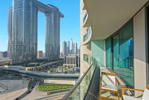 Un immeuble de grande hauteur, doté d’un sommet incurvé, d’une façade moderne en verre et offrant une vue sur un paysage urbain avec d’autres bâtiments imposants.