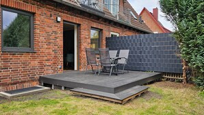 A brick house with a small outdoor stage and seating area. - Quiet 2 room apartment with WLAN on the first floor - MH5 (Markgrafenheide)
