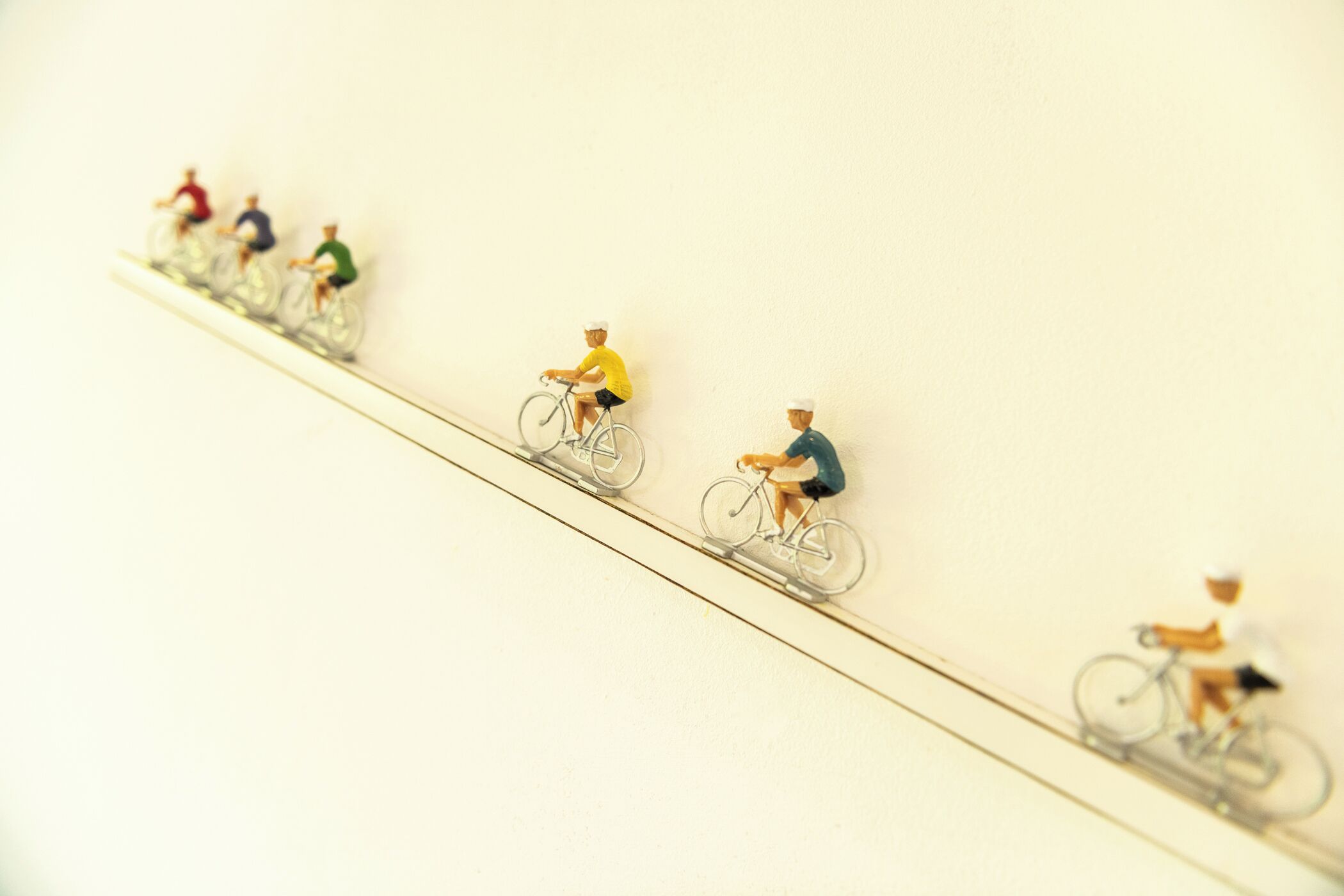 A row of miniature bicycles on a wall.