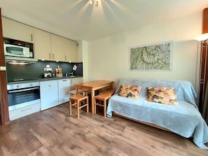 Cozy living space with a kitchenette, dining table, and comfortable seating area.