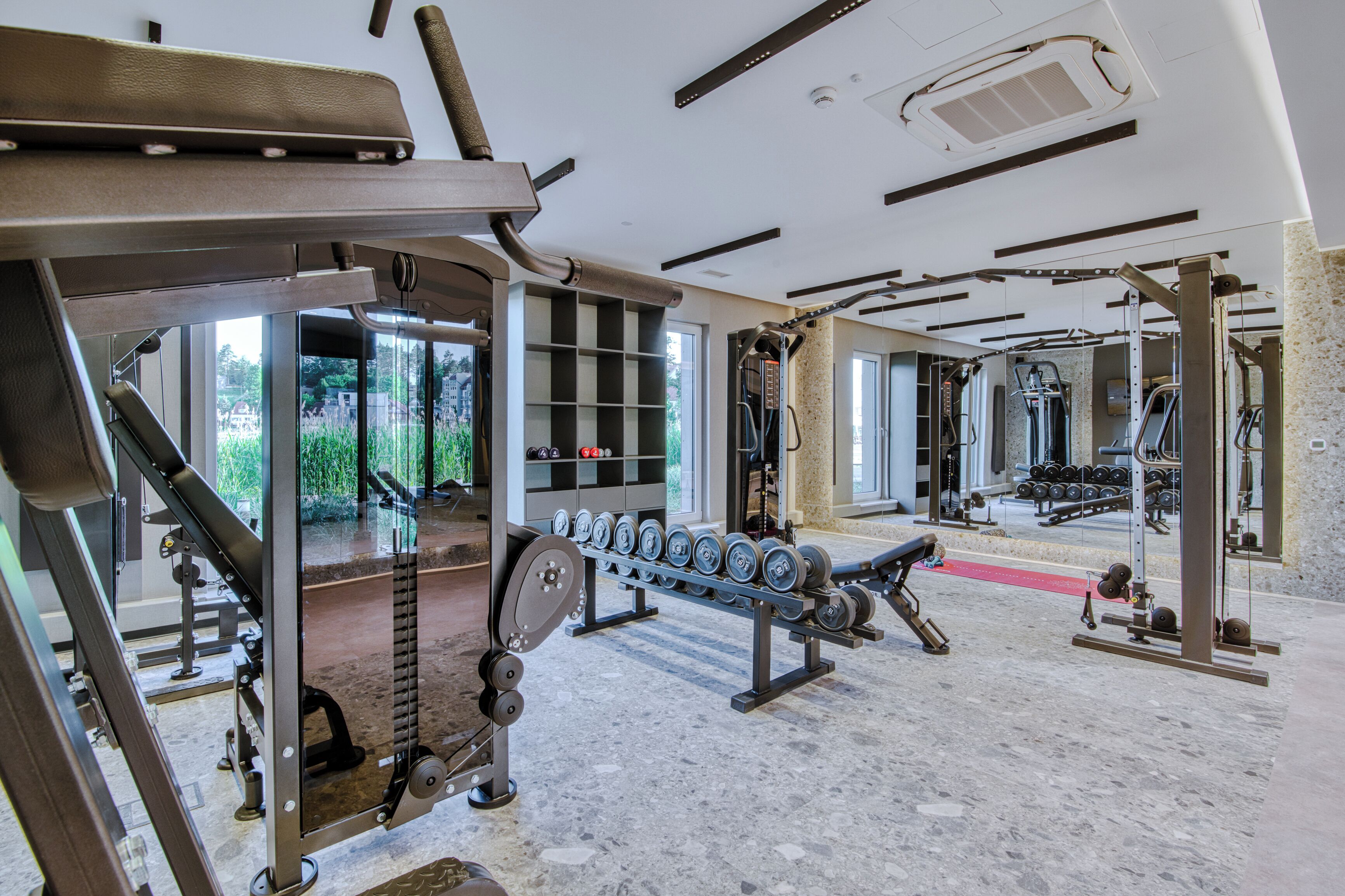 Een sportschool met diverse fitnessapparaten, waaronder gewichten en krachttoestellen.