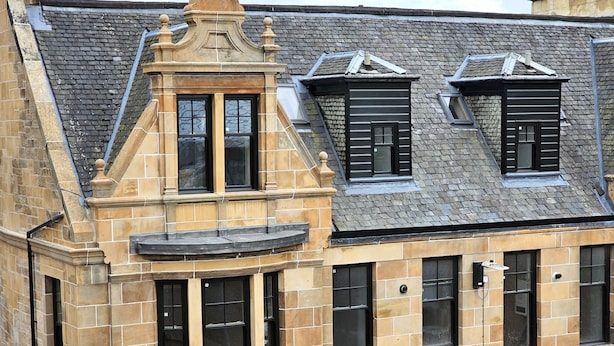 A historic building with a stone facade, multiple windows, and a steeply pitched roof. - Central Paisley Apartment- Airport/glasgow Access (Paisley)