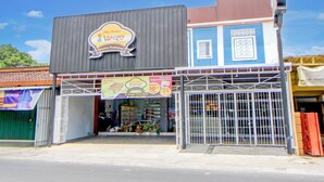 A building with a sign reading "Yanizo" and a storefront with a metal gate. - Capital O 94314 Sunny Co Living (Banguntapan)