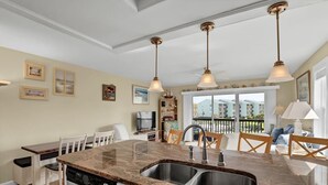 Eine Küche mit Granit Arbeitsplatte, Edelstahlspüle und Pendelleuchten.