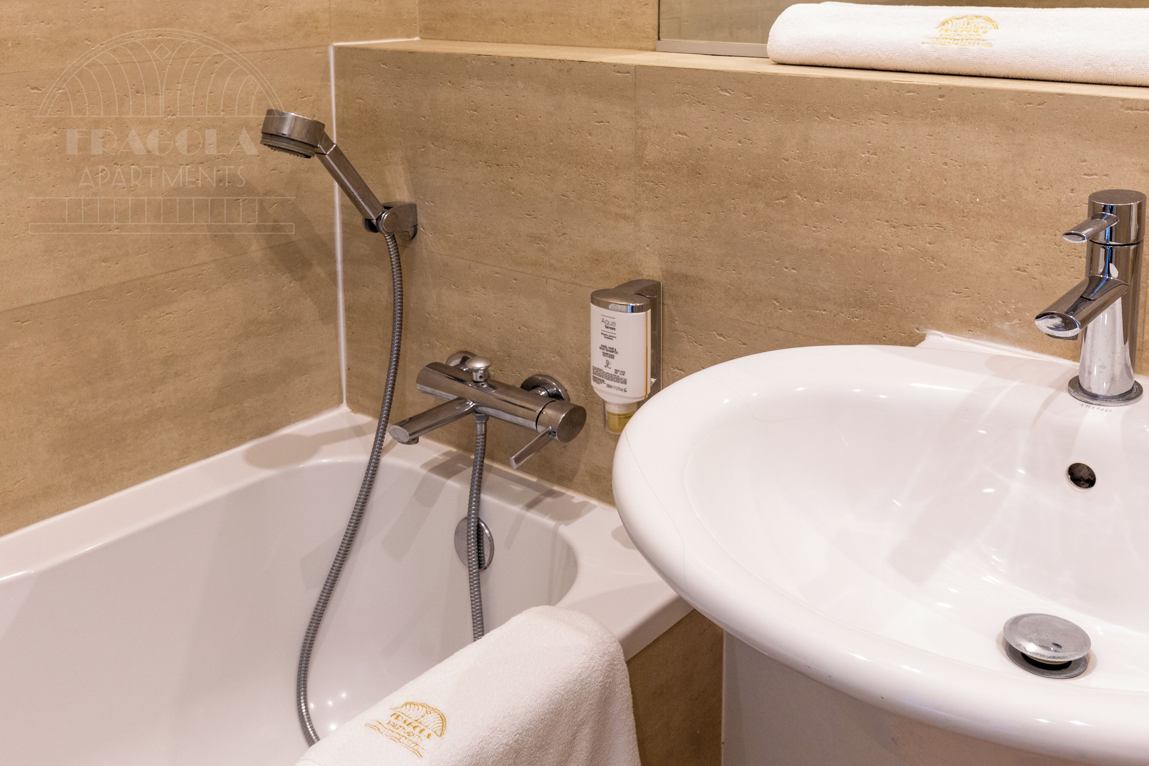 A bathroom with a bathtub, a sink, and a towel rack.