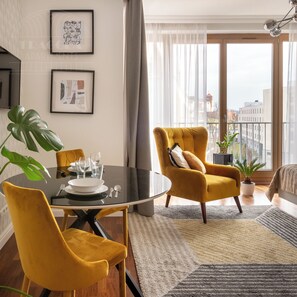 Suíte estúdio luxo, sacada, vista para a cidade | Área de estar | TV