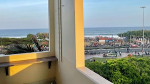 A balcony with a view of a busy street and the ocean. - Ocean's Edge by Natti's group (Visakhapatnam)
