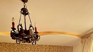 Une chambre d’hôtel avec un grand lit, un lustre, un mur décoré d’un motif en briques et un plancher en bois.
