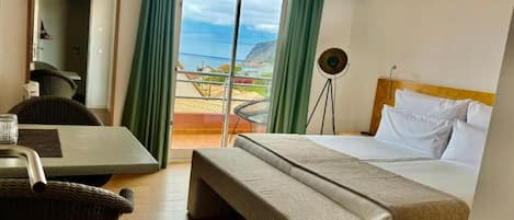 Ein Hotelzimmer mit Bett, einer Sitzbank, einem Tisch und einem Stuhl.