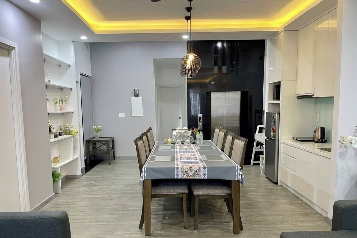 Un espace de salle à manger moderne, avec une longue table, des chaises et un chemin de table décoratif.