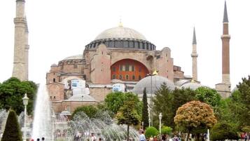 A historic building with a large central dome and four minarets.