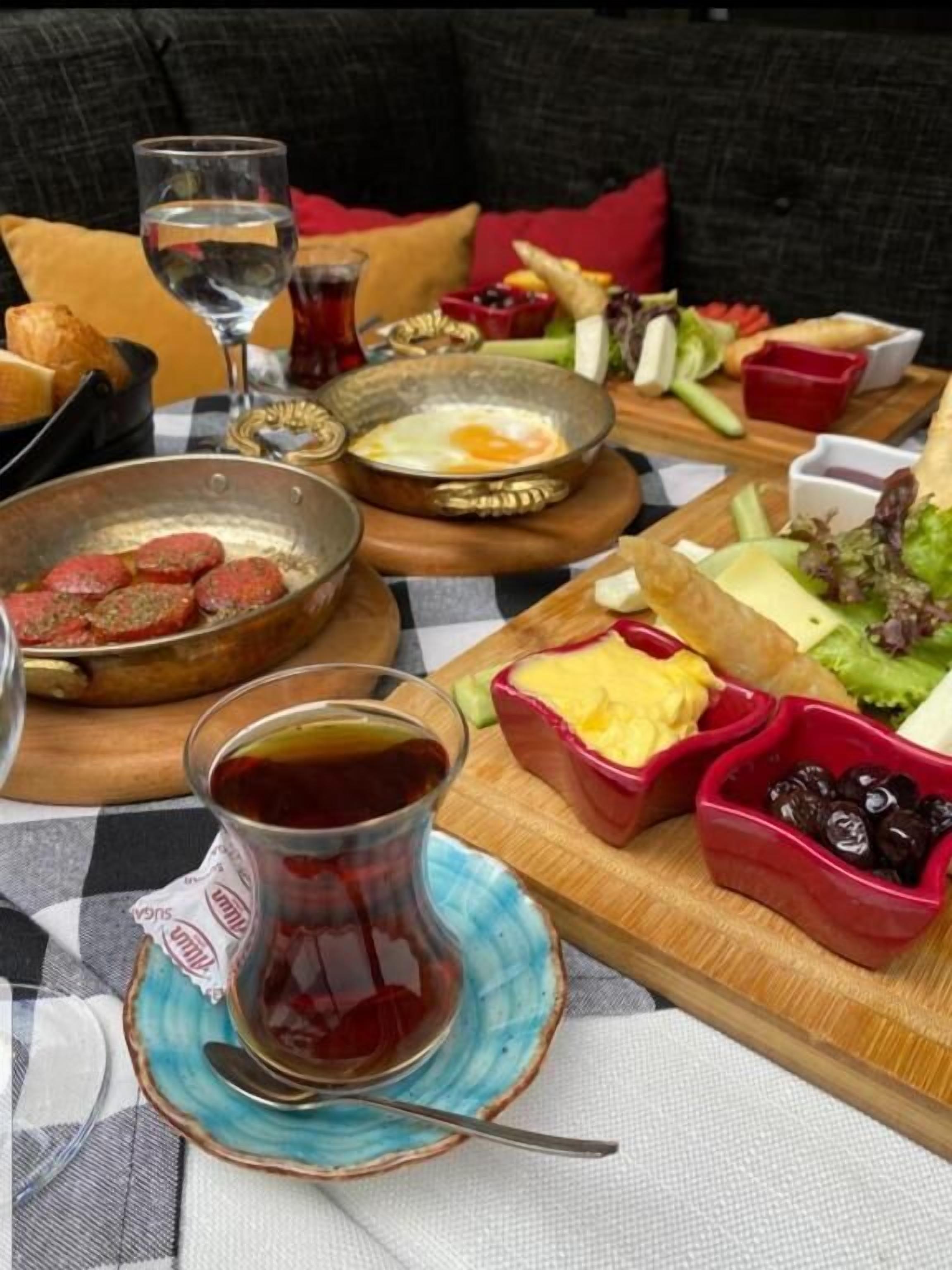 A table set with a variety of dishes including a bowl of meat, a plate with eggs, and several small bowls of dips and vegetables.
