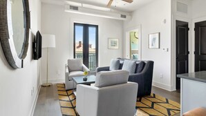 Ein modernes Wohnzimmer mit Deckenventilator, großem Spiegel und einer Couch.