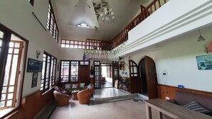 Un intérieur spacieux avec de hauts plafonds, des rampes en bois et un escalier menant à un niveau supérieur.