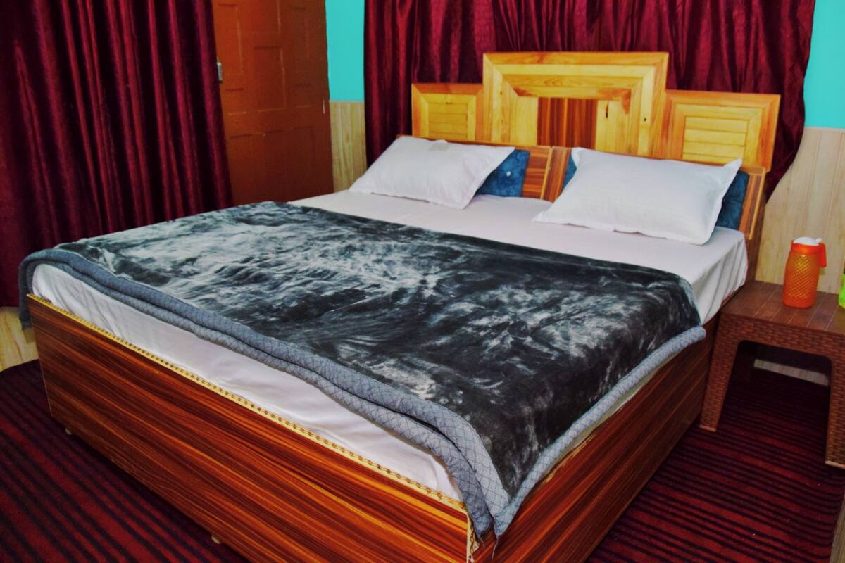 A bed with a wooden headboard and a patterned bedspread.