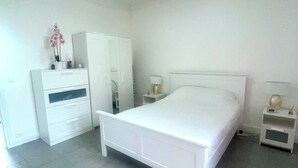 A bedroom with a bed, a wardrobe, a nightstand, and a small table with a lamp. - Spacious and bright, a real "coup de coeur" near the metro and RER station (La Courneuve)