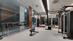 A modern gym with weightlifting equipment, a bench, and a mirrored wall. - Brabank 20 by Grand Apartments (Gdansk)