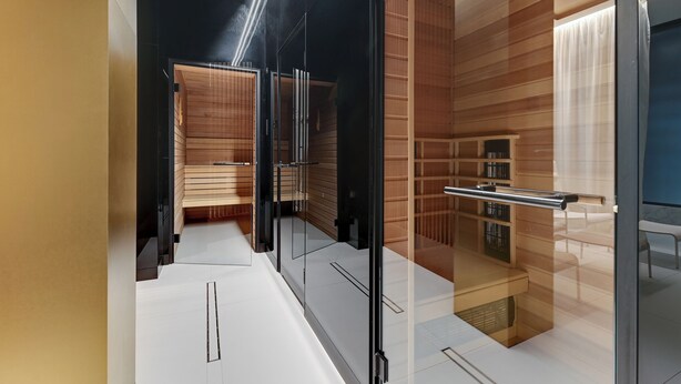 A modern interior with a wooden panel wall, a glass partition, and a metal railing. - Brabank 20 by Grand Apartments (Gdansk)