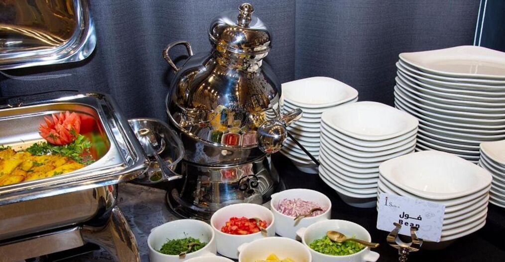 A buffet setup with various food items and a coffee machine.