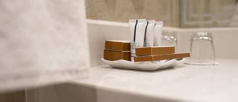A bathroom counter with toiletries and a glass of water.