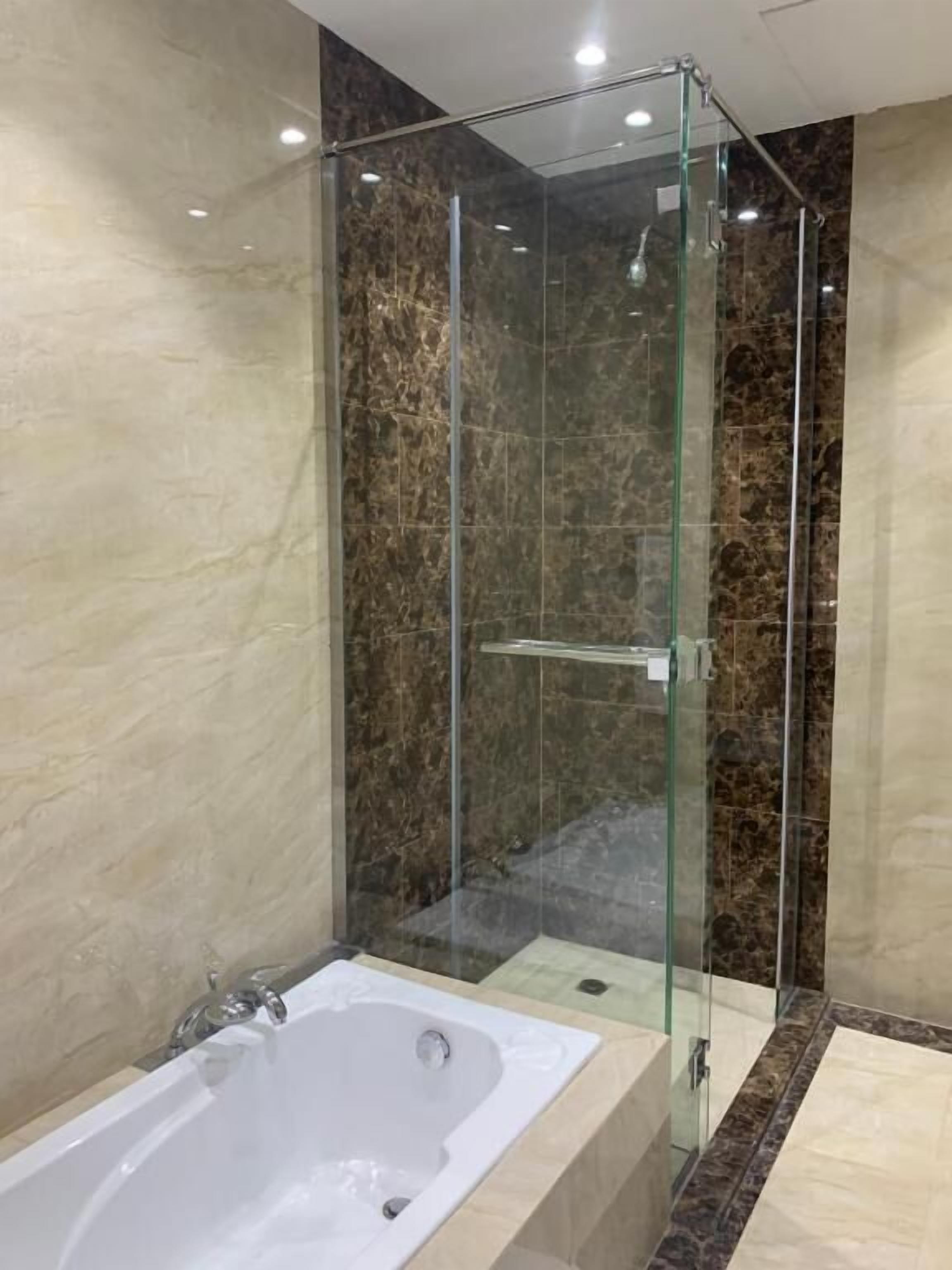 A modern bathroom with a glass-enclosed shower and a standalone bathtub.