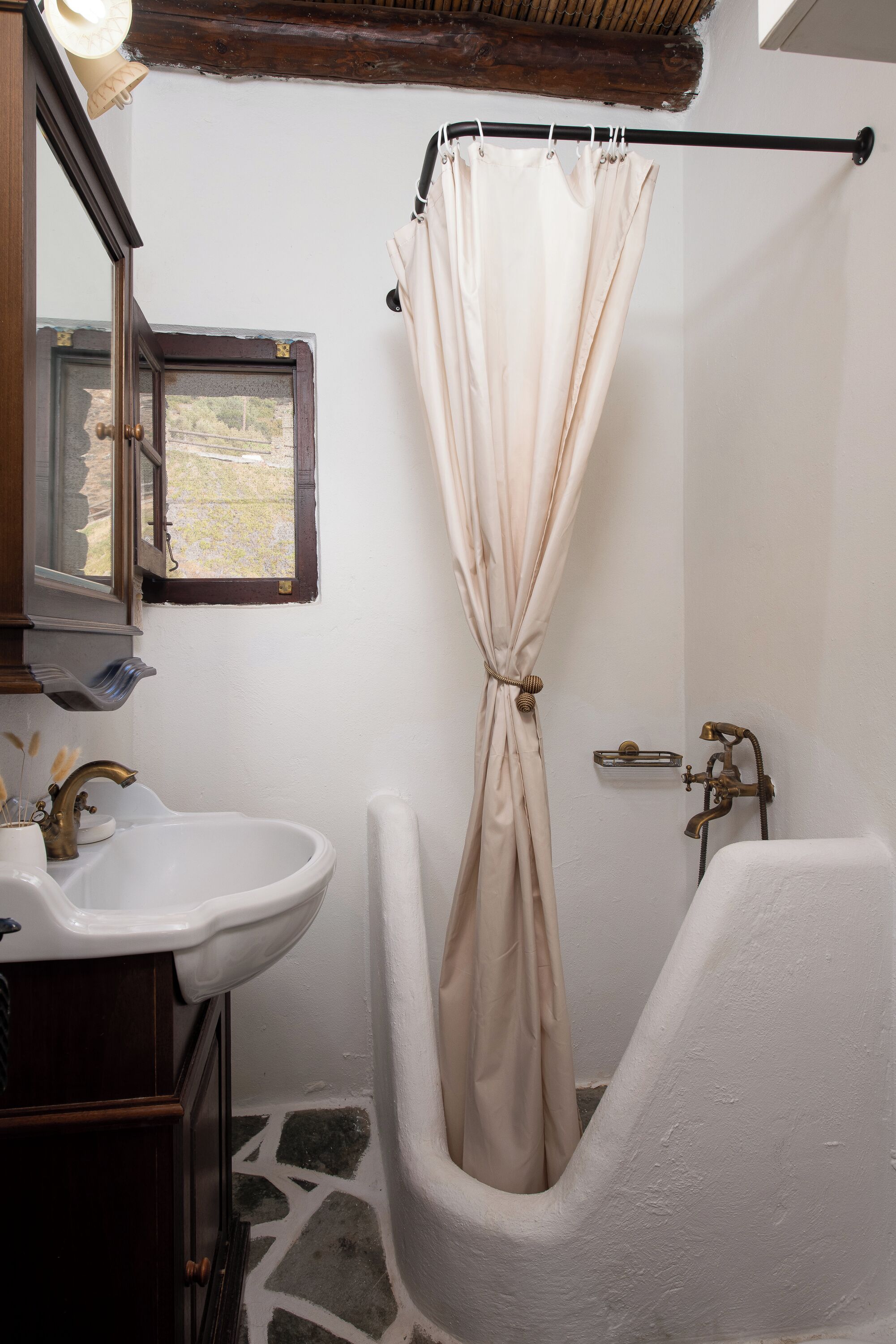 A bathroom with a bathtub, a sink, and a window.