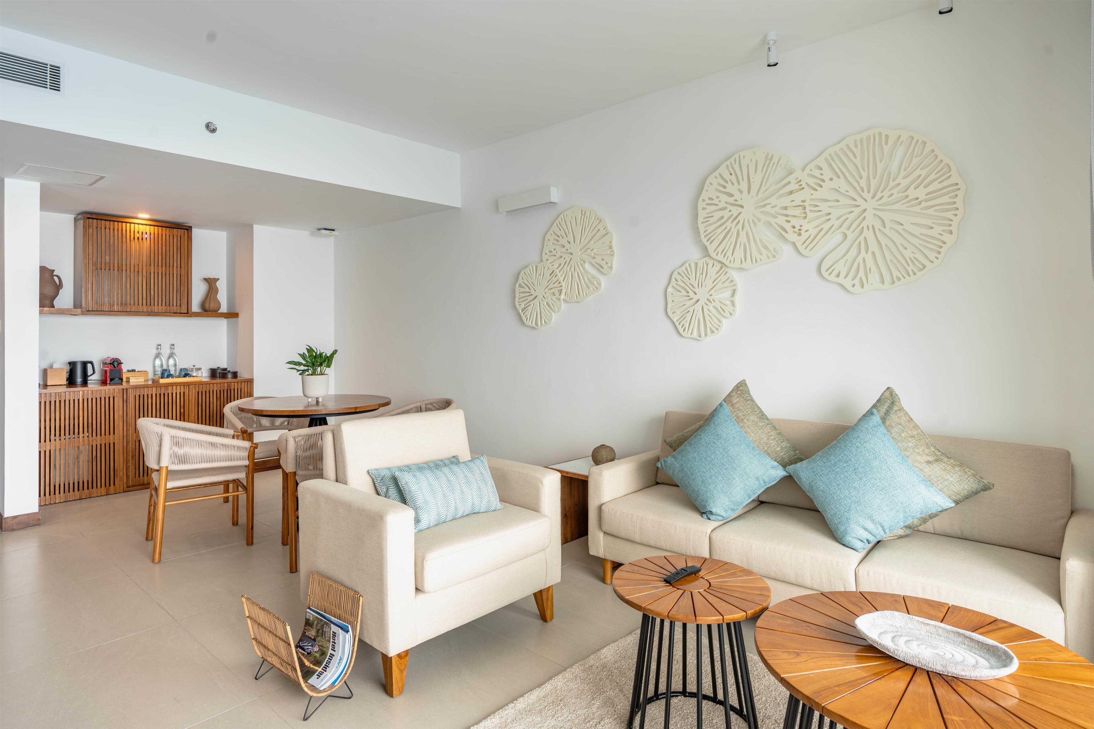 A modern living room with a sofa, armchairs, a coffee table, and decorative wall art.