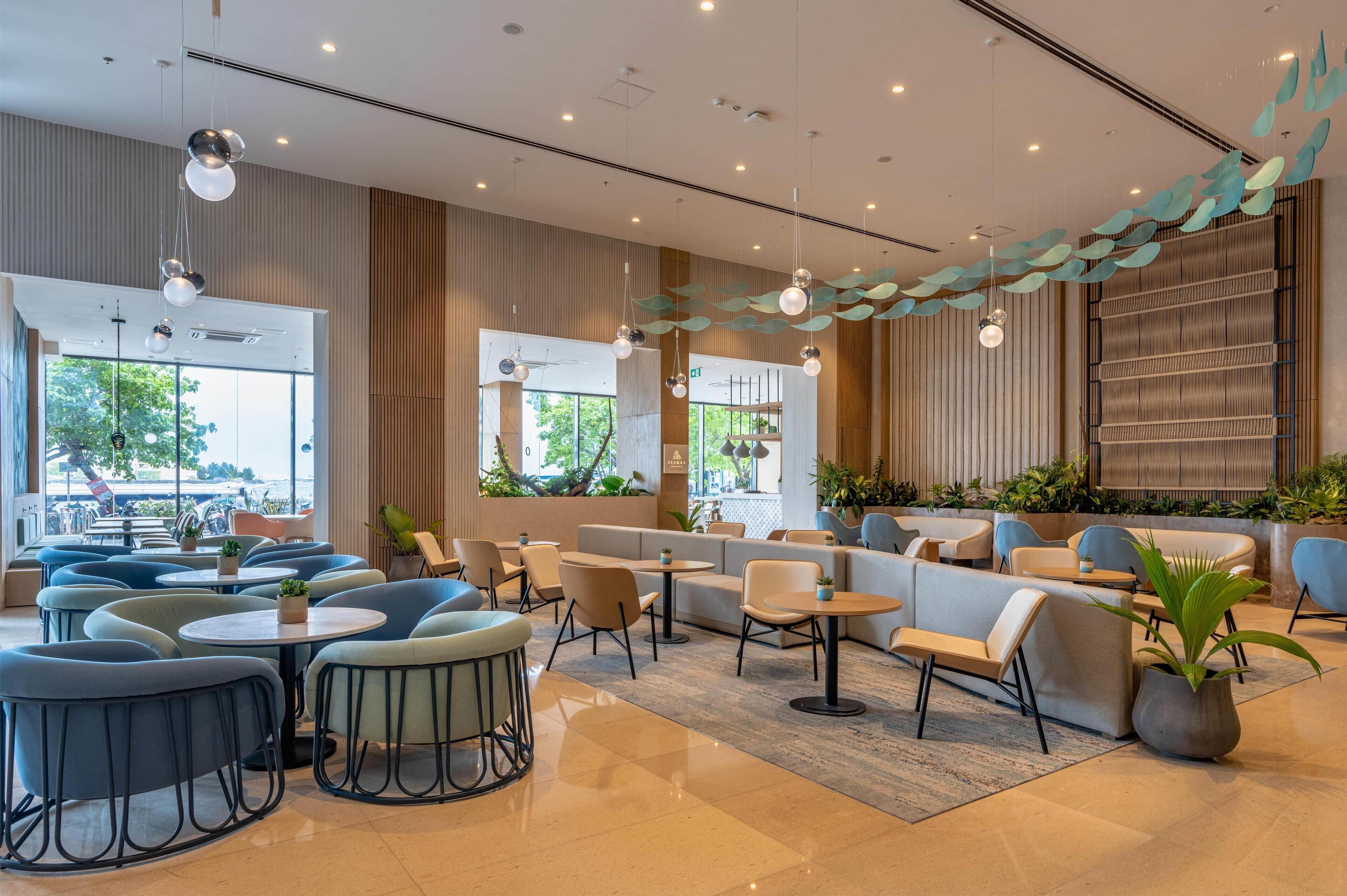 Un espace intérieur moderne, aménagé avec des coins salon, des tables et des éléments décoratifs.