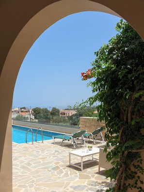 Area piscina con vista aperta sul mare e edifici sullo sfondo.