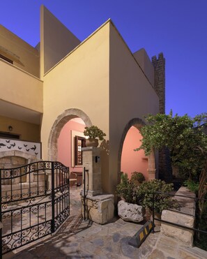 A courtyard with stone steps, a gate, and an archway leading to a building. - Abrakamus By Forest Villas (Rethymno)