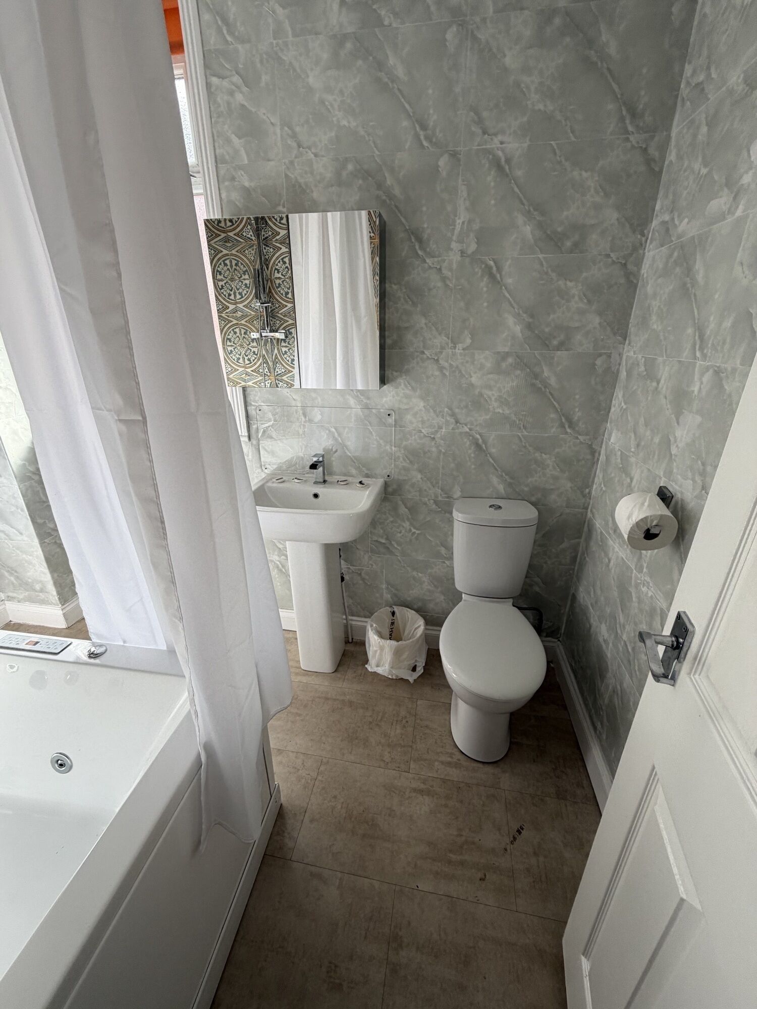 Un bagno con vasca, lavandino, WC e tenda da doccia.