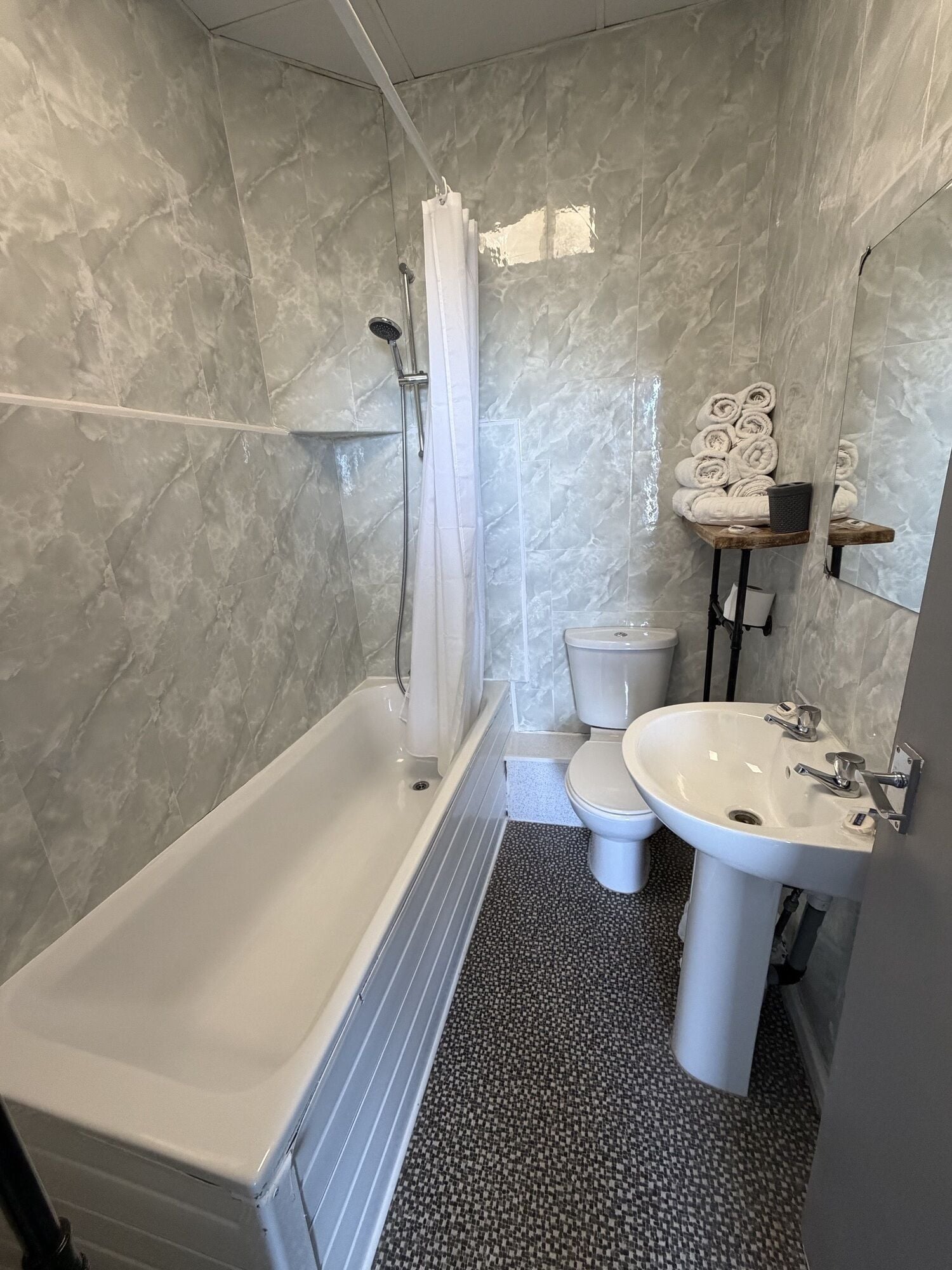 A bathroom with a bathtub, toilet, and sink.