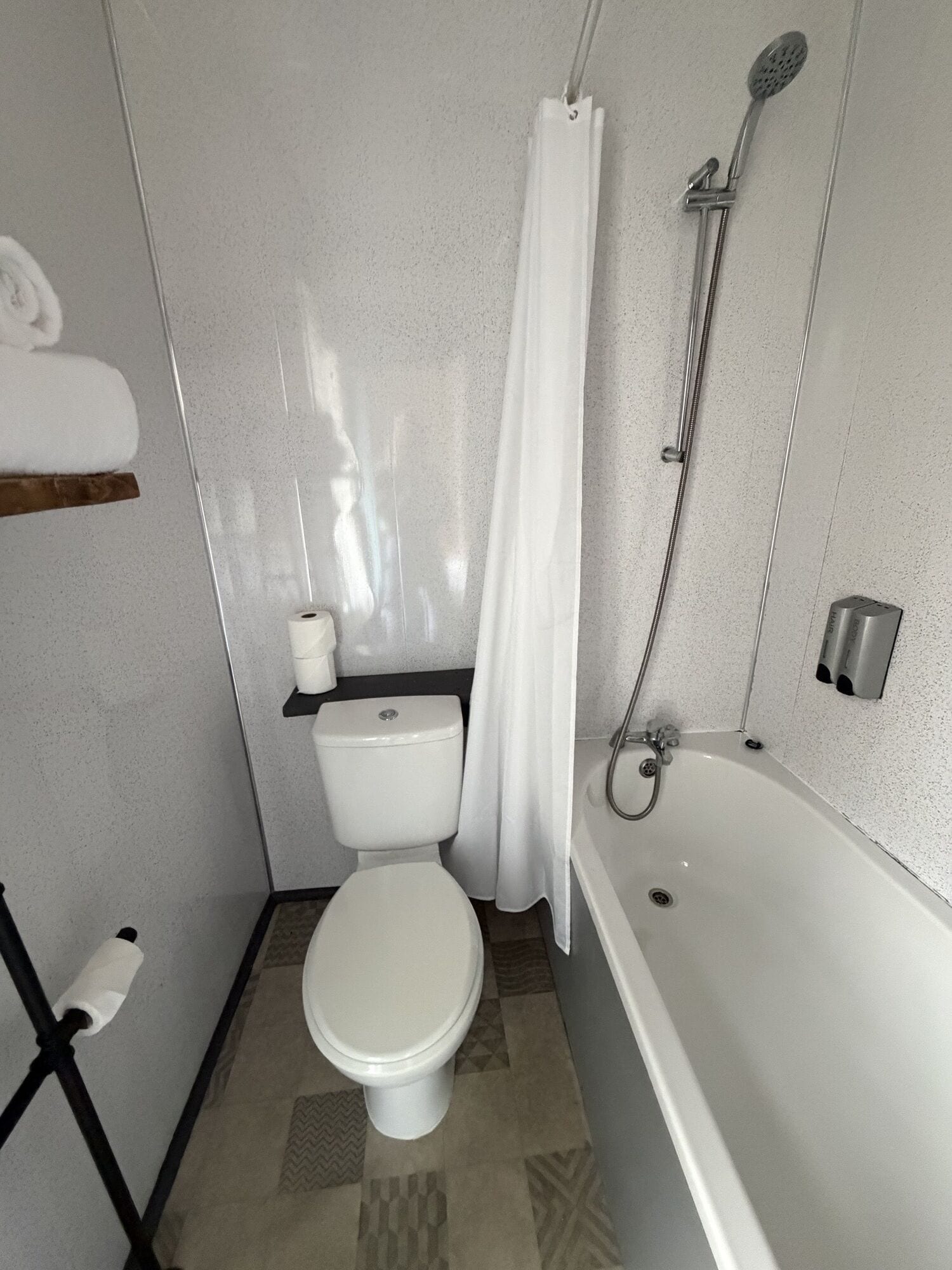 A bathroom with a toilet, shower, and bathtub.
