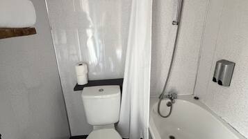 A bathroom with a toilet, shower, and bathtub.